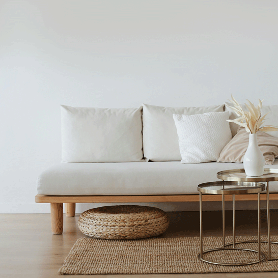 Living room with a white sofa, beige rug, and coffee tables to illustrate how to remove stains from home textiles: sofas, armchairs, rugs, tablecloths, and more